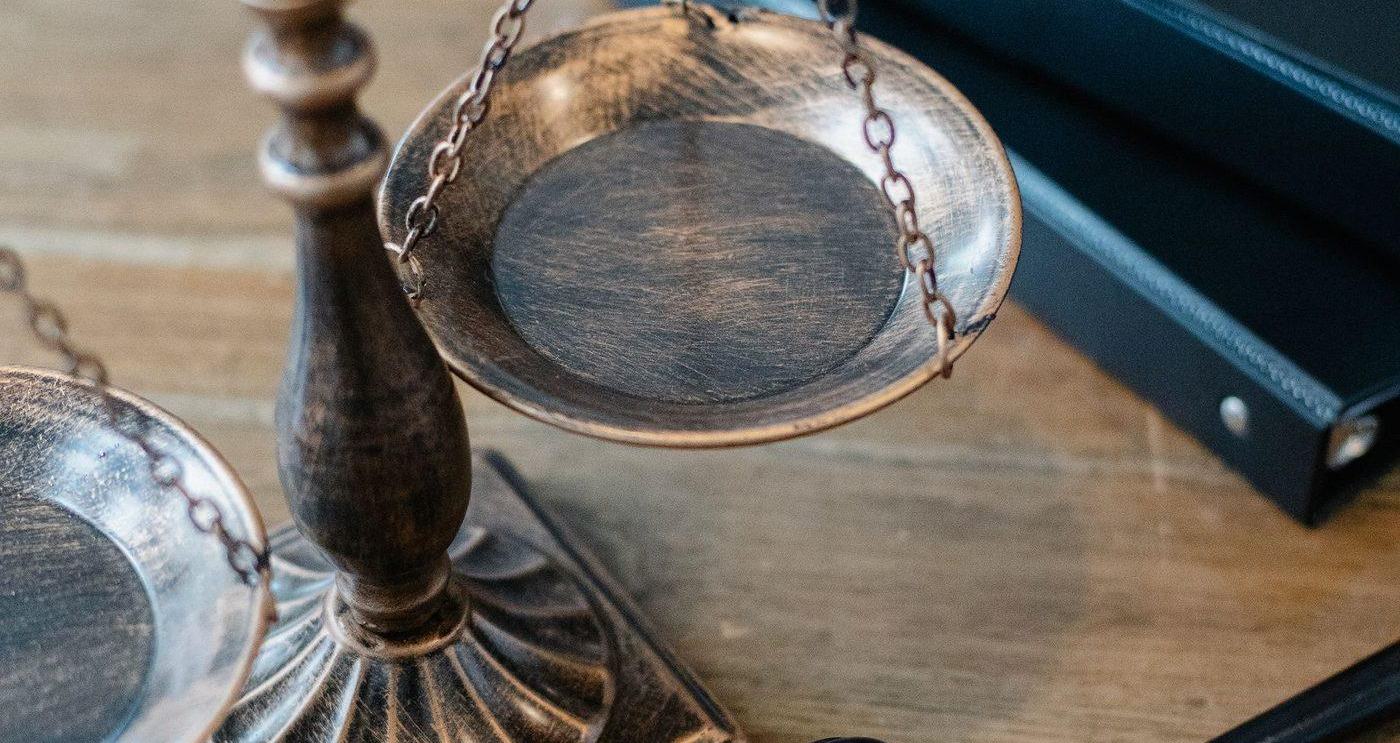 Scales of justice and a gavel on a wooden surface